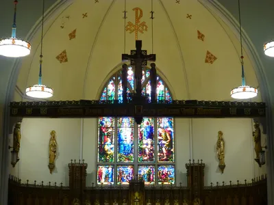 Wood beam and crucifix. The inscription reads: "Come adore Christ the King who was exalted to the cross for us." This is the invitatory antiphon for the Exaltation of the Holy Cross in the Divine Office.