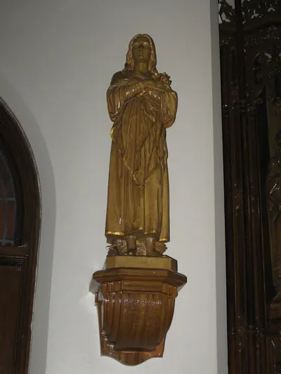 Statue. Inscription reads: "The more you honor me, the more will I bless you." This saying is attributed to the Infant of Prague, which makes me wonder if the Infant statue (on the right side of the church, see next photo) was originally located on this pedestal.