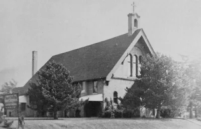 Old photograph of church exterior. Note the cross atop the bell tower. Source: Henrietta Heritage