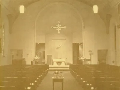 Interior after renovation in 1973. The church is largely the same today with the exception of a crucifix above the altar instead of the 1973 cross. Source: Holy Ghost 100 years