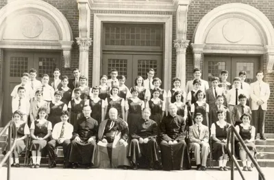 Class of 1956 on front steps of church.