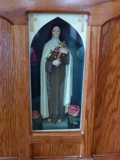 Small statue of St. Theresa in the base of the larger statue.