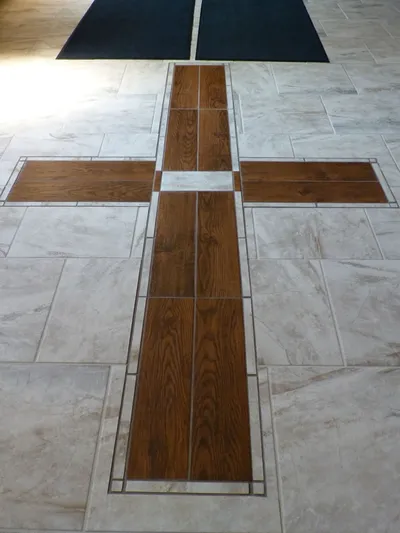 Wood cross on the floor leading into the church.