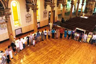 Prayer circle after Mass during the late 1990s to early 2000s. The back pews and part of the altar railing were removed as part of a church rennovation in the mid-1990s. Both have since been restored by the Coptic community. Source: Defunct parish Web site