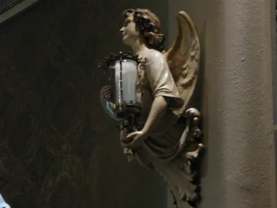 Angel holding sanctuary lamp.