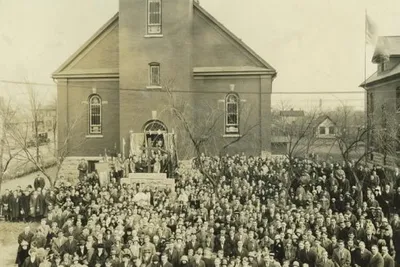 Parishioners standing outside Ss. Peter and Paul church, Mar. 8, 1925. Note the stained glass windows instead of icons on the lower level.