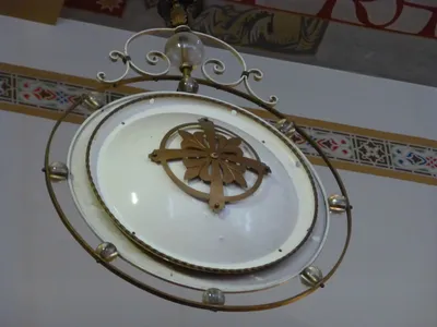 Very old lamp hanging from ceiling.