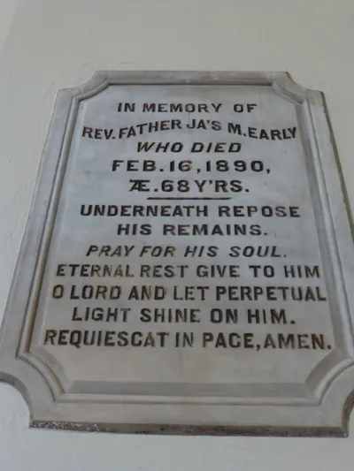 Memorial plaque. Former pastor is buried underneath the high altar.