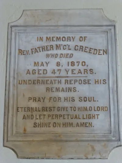 Memorial plaque. Former pastor is buried underneath the high altar.