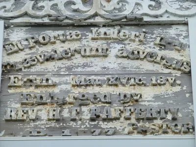 Inscription on the front of the church. Very hard to read with the paint peeling and lettering falling apart.