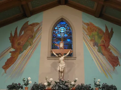 Crucifix and paintings on sanctuary wall.