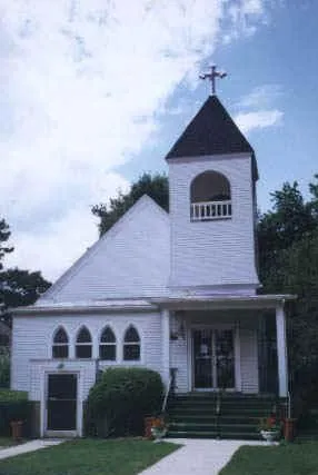 Former appearance of the church exterior. Two significant modifications include the reduction of front entrances from two to one, and the rearrangement of stained glass windows on the left side of the facade. Compare with present appearance.