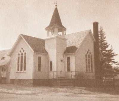 The former Elmgrove Methodist church was home to the new parish before the first church was purchased and ready for use. This is an image of that church in 1963. Today, the building houses various small businesses. Source: From the Wilderness: Town of Gates Sesquicentennial, 1813-1966
