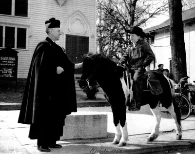 Fr. Reddington outside former church, 1959. Source: A Home For All God's People: The Story of St. Louis Church, 1884-1999