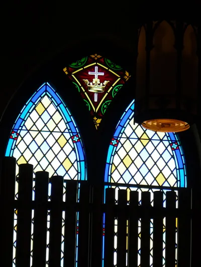 The small triangular window at the top is the only stained glass that was originally in the church. All others have been replaced.