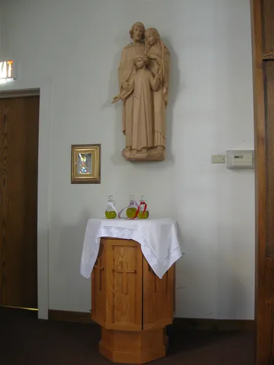 Wall-mounted holy family statue and chrisms.