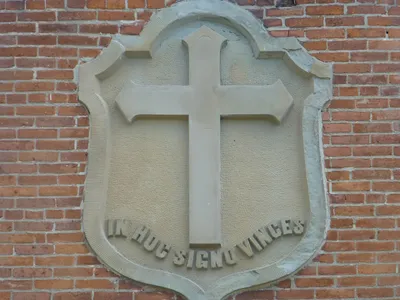 Crest above main entrance. Trans: "In this sign, conquer"