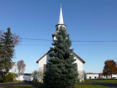 Church seen straight on (with pine tree in the way).