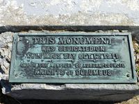 Dedication plaque at cross base.